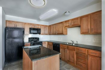 a kitchen with black appliances and wooden cabinets